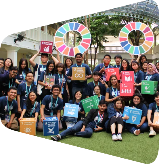 a group AIESECers holding up signs with the SDGs in front of a building