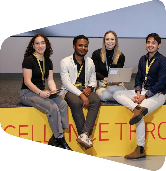 Global Talent participants standing on the edge of a indoor platform smiling at the camera