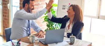 Co-workers high fiving